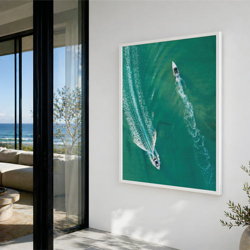 High end coastal print of boats on crystal blue water with white wash following